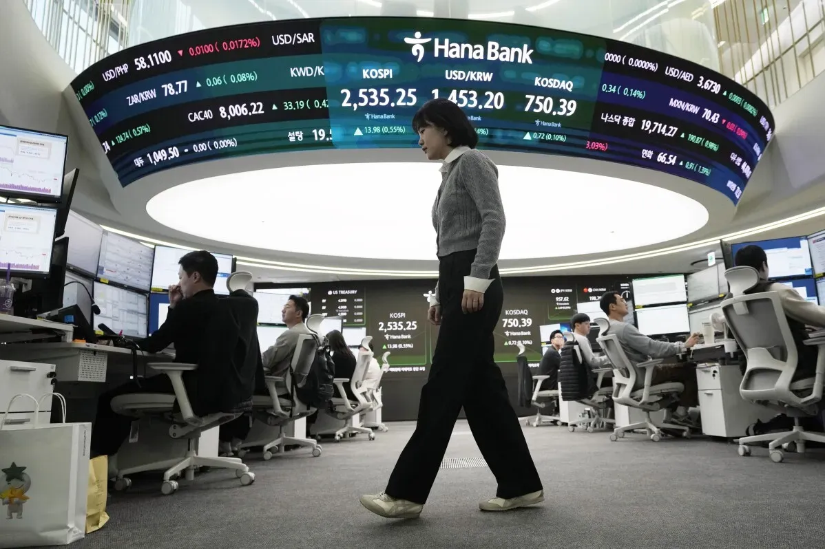 مستثمرون في غرفة تداول، مع شاشات تعرض مؤشرات الأسهم وأسعار العملات، في سياق تراجع الأسواق الآسيوية بسبب الرسوم الجمركية الأمريكية.