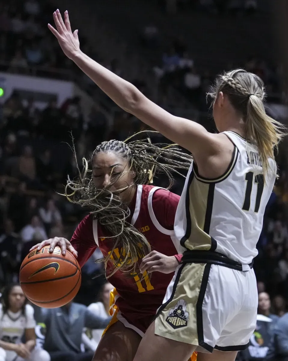 لاعبة كرة سلة من جامعة جنوب كاليفورنيا تت dribble الكرة بينما تحاول لاعبة من بوردو، ترتدي الرقم 11، الدفاع عنها في مباراة قوية.