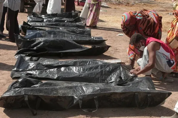 جثث مغطاة بأكياس سوداء في موقع حادث عنيف، مع وجود شخص يقوم بفحص أحد الأكياس، مما يعكس تأثير الصراع في دارفور.