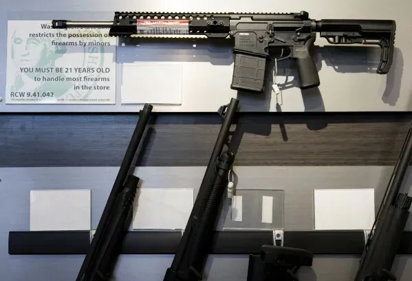 بندقية AR-15 موضوعة على حائط عرض، مع لافتات تحذر من قيود شراء الأسلحة، تعكس الجدل حول قوانين الأسلحة في الولايات المتحدة.
