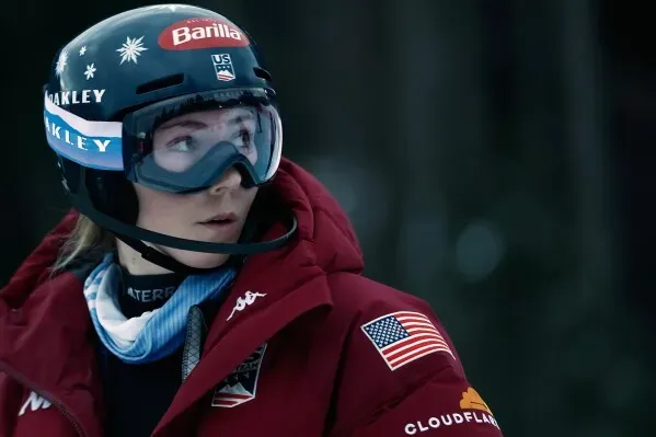 كاميل راست، المتزلجة السويسرية، ترتدي خوذة ونظارات تزلج، وتظهر بملابس دافئة، تستعد للمنافسة في سباق التزلج المتعرج.