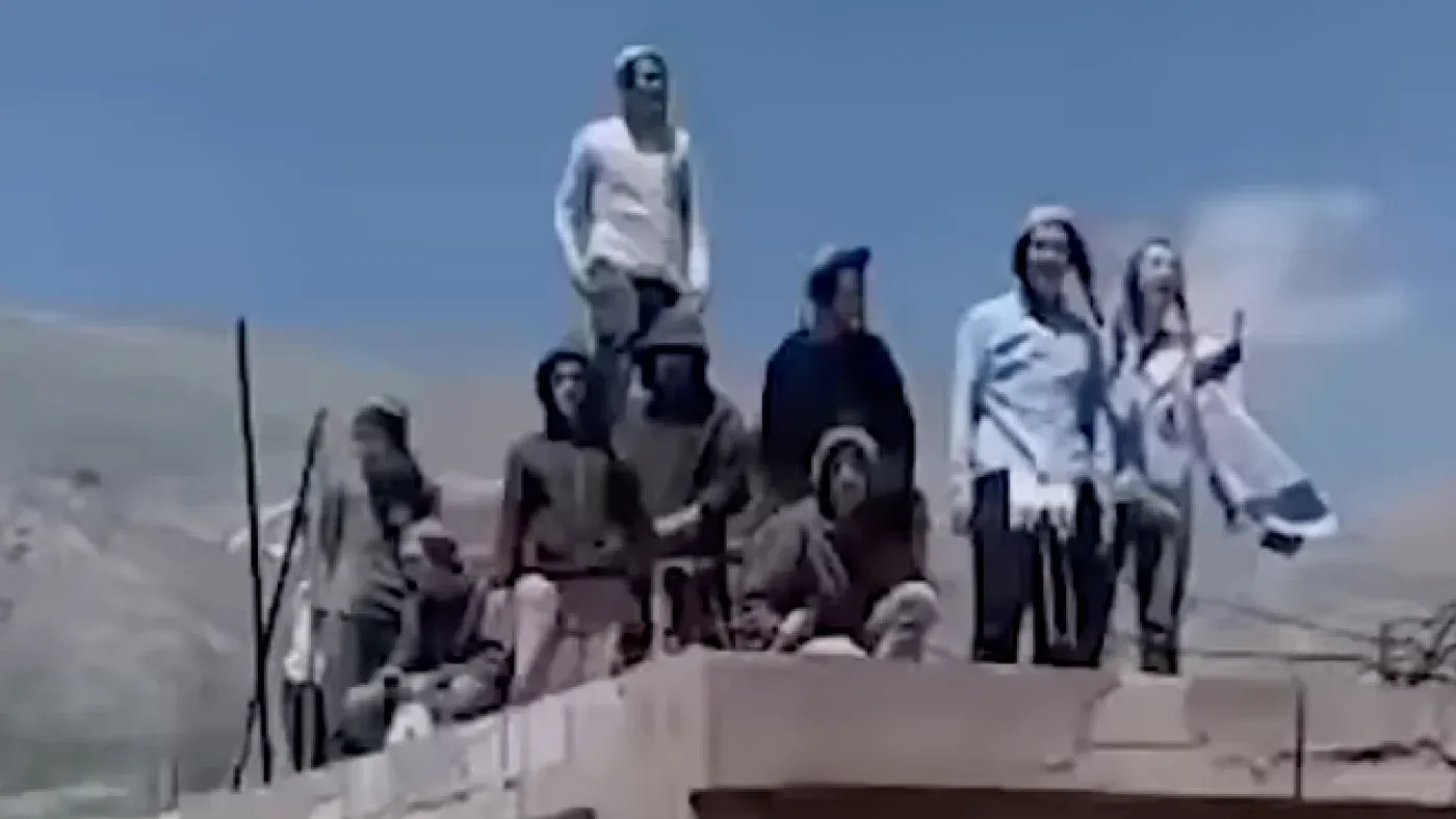 مجموعة من المستوطنين الإسرائيليين يقفون على سطح مبنى في منطقة الجولان، يحملون الأعلام الإسرائيلية ويعبرون عن رغبتهم في إقامة مستوطنة جديدة.