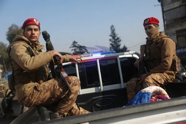 عناصر من قوات الأمن السورية يرتدون زيًا عسكريًا، يجلسون على شاحنة في حلب، وسط توتر بعد إعلان وقف إطلاق النار.