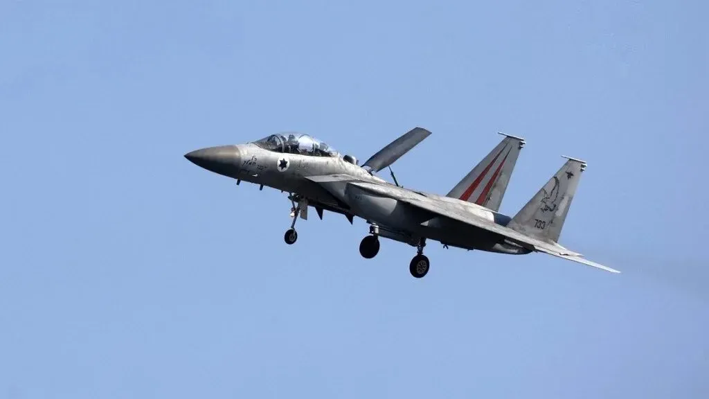 طائرة حربية إسرائيلية من طراز F-15 تحلق في السماء، تعكس تصعيد الغارات الإسرائيلية على سوريا وتأثيرها على الوضع الأمني الإقليمي.