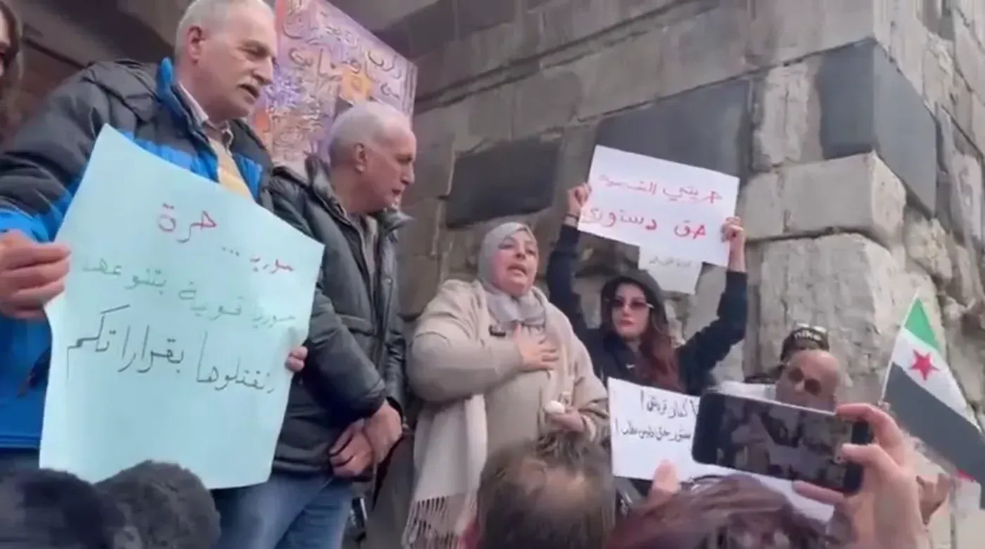 احتجاجات في دمشق ضد حظر بيع الكحول، حيث يظهر المتظاهرون يحملون لافتات تعبر عن مطالبهم، مع خلفية تاريخية للمدينة.