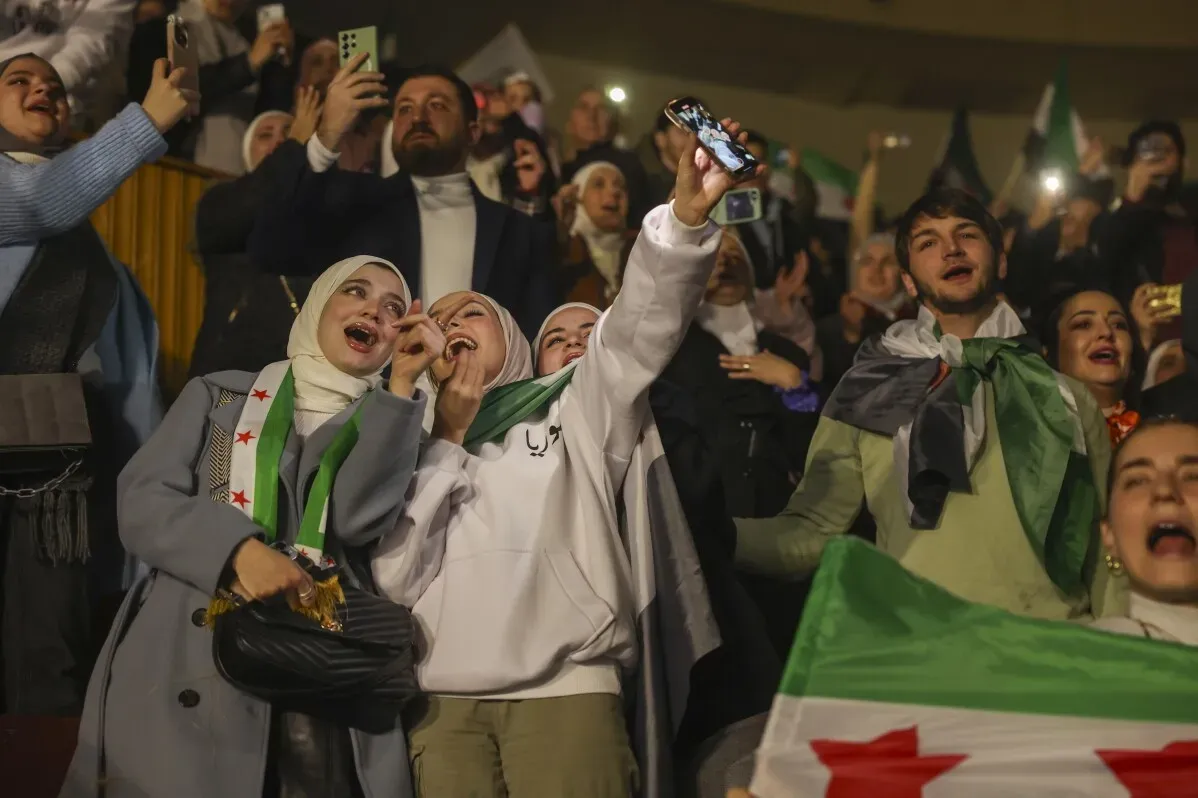 جمهور متحمس في قاعة الحفل بدمشق، يرفع الأعلام السورية ويغني معاً احتفالاً بعودة المغني وصفي المعصراني بعد 13 عاماً من المنفى.