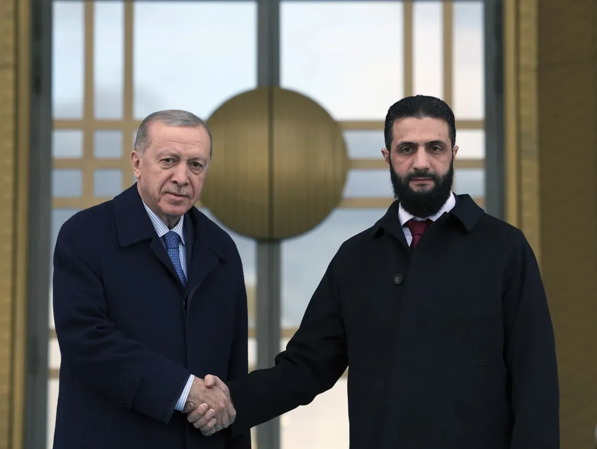 أحمد الشرع، الرئيس السوري المؤقت، يتصافح مع الرئيس التركي رجب طيب أردوغان في أنقرة، وسط خلفية القصر الرئاسي، أثناء محادثات حول الانتعاش الاقتصادي.