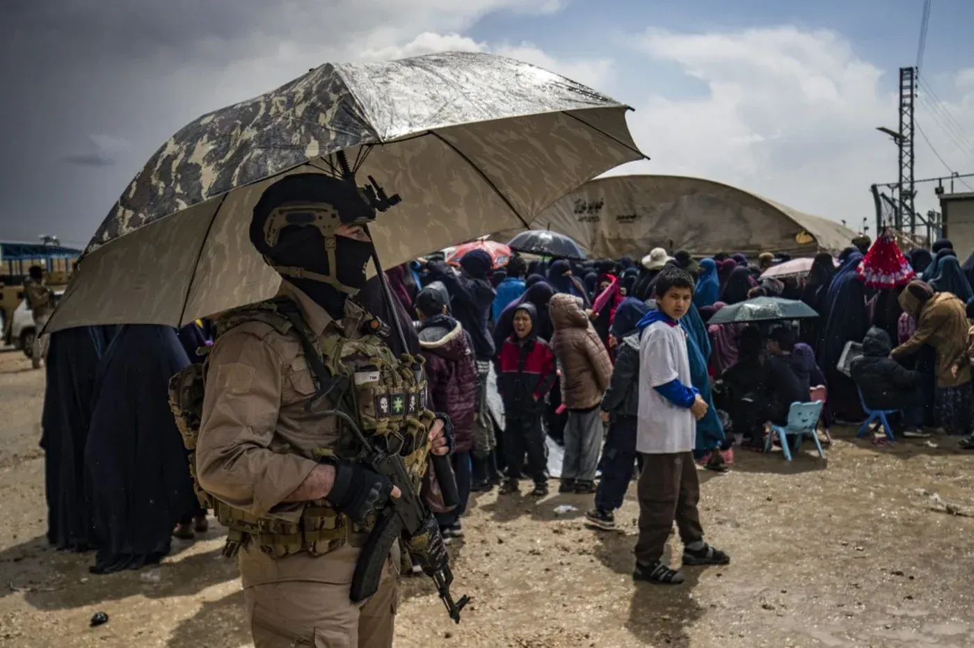 عناصر من قوات سوريا الديمقراطية يراقبون مخيم الروج، حيث يتجمع عدد كبير من العائلات، وسط ظروف صعبة وتوترات متزايدة.