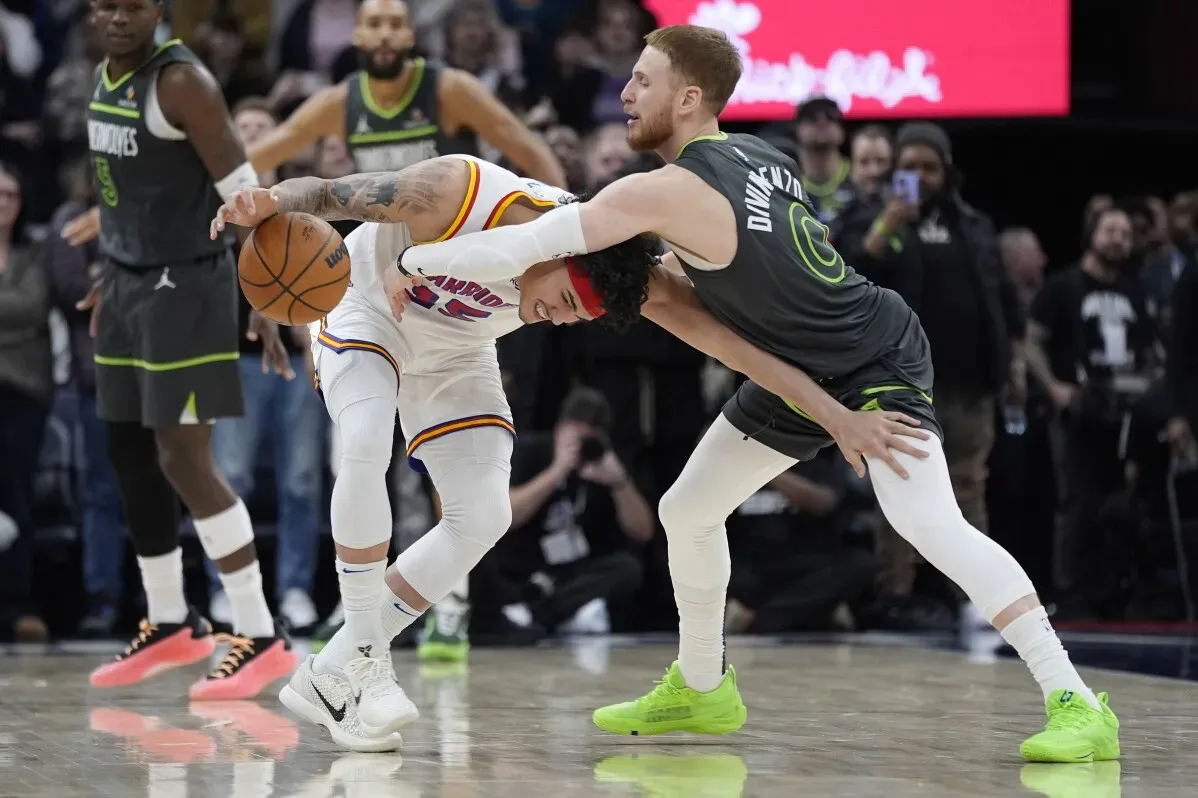 مواجهة حماسية في مباراة كرة سلة، حيث يتنافس لاعب من فريق مينيسوتا تمبروولفز مع خصمه على الكرة في لحظة حاسمة.