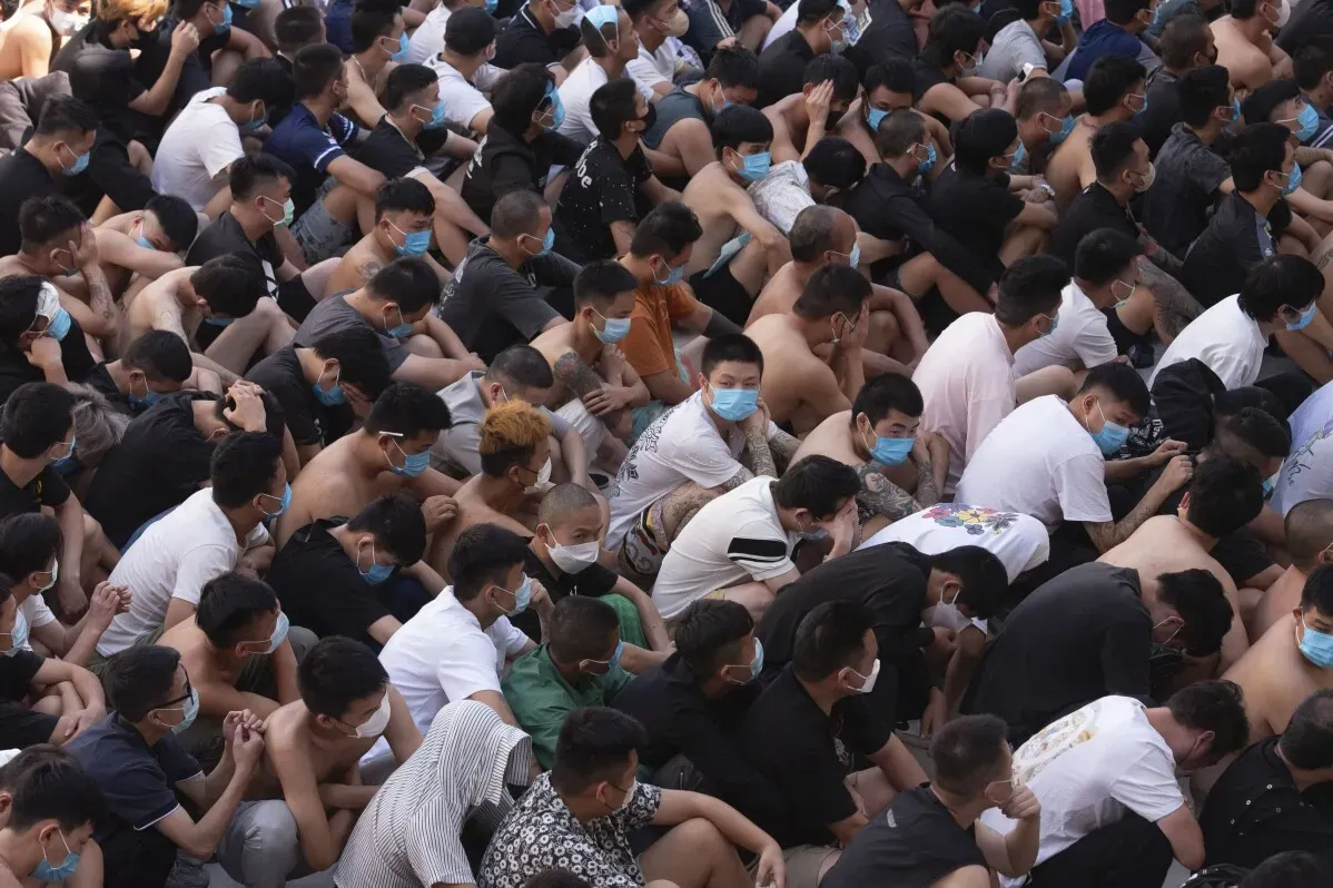 آلاف الأشخاص المحتجزين في ظروف قاسية، يجلسون معًا في صفوف مرتبة، يرتدون أقنعة وجه، في معسكرات تسيطر عليها جماعات مسلحة في ميانمار.