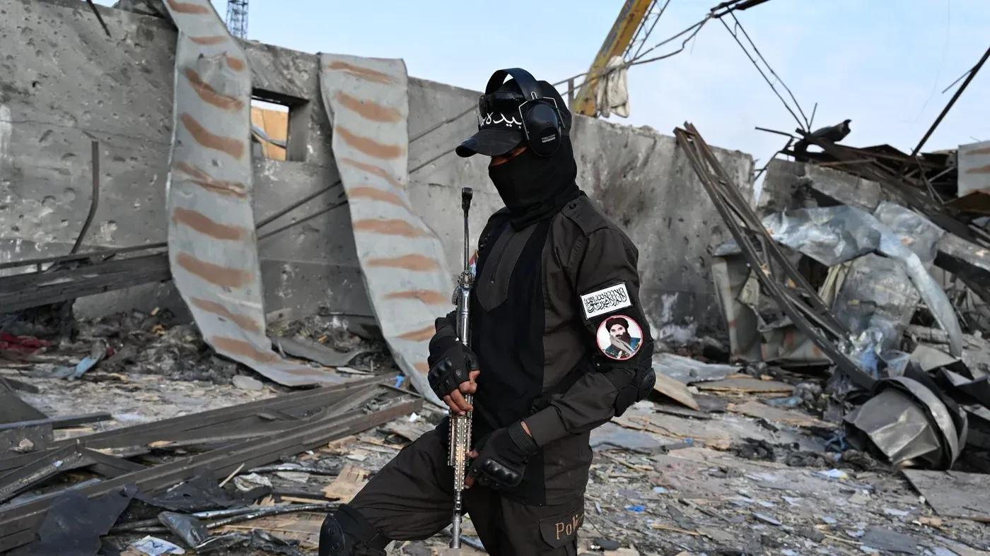 رجل مسلح يرتدي زيًا أسود يقف وسط أنقاض مستشفى أوميد في كابول، بعد الهجوم الذي أسفر عن مقتل 400 شخص.