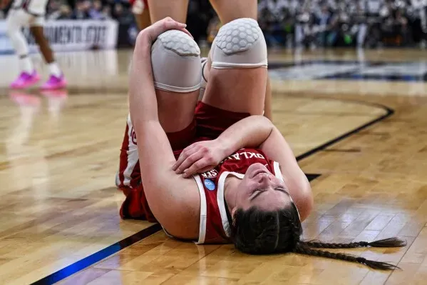 لاعبة كرة سلة من فريق أوكلاهوما تتألم على أرض الملعب بعد تعرضها لإصابة خلال مباراة بطولة NCAA للسيدات.