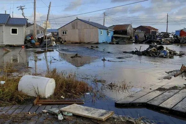 تظهر الصورة منازل متضررة ومياه مدمرة في قرية ألاسكية بعد إعصار هالونج، مما يعكس آثار الكارثة على المجتمعات المحلية.