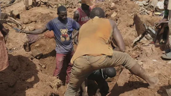 مجموعة من الأشخاص يعملون في إزالة الأنقاض بعد الفيضانات المدمرة في موكوا، نيجيريا، حيث يسعون للعثور على ناجين أو ضحايا.
