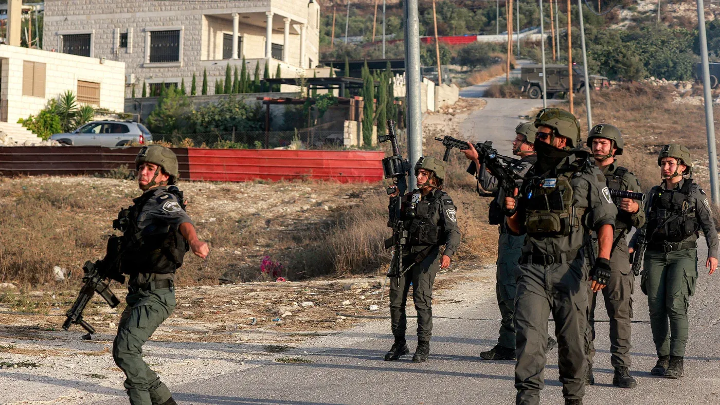 جنود إسرائيليون مسلحون في طريق قرية تل الفلسطينية بالضفة الغربية خلال توتر بعد مواجهات مع مستوطنين مسلحين.