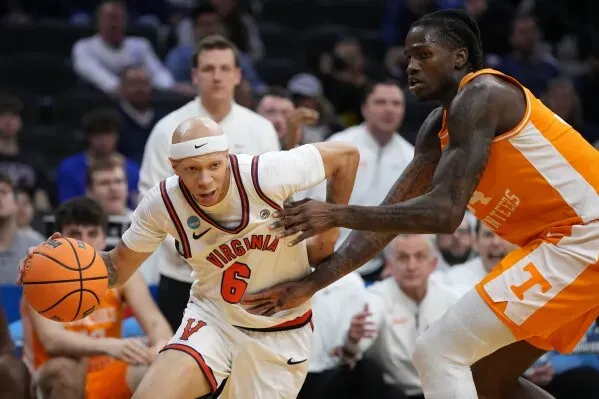 لاعب من فريق فيرجينيا يحاول السيطرة على الكرة بينما يضغط عليه لاعب من فريق تينيسي في مباراة بطولة NCAA.