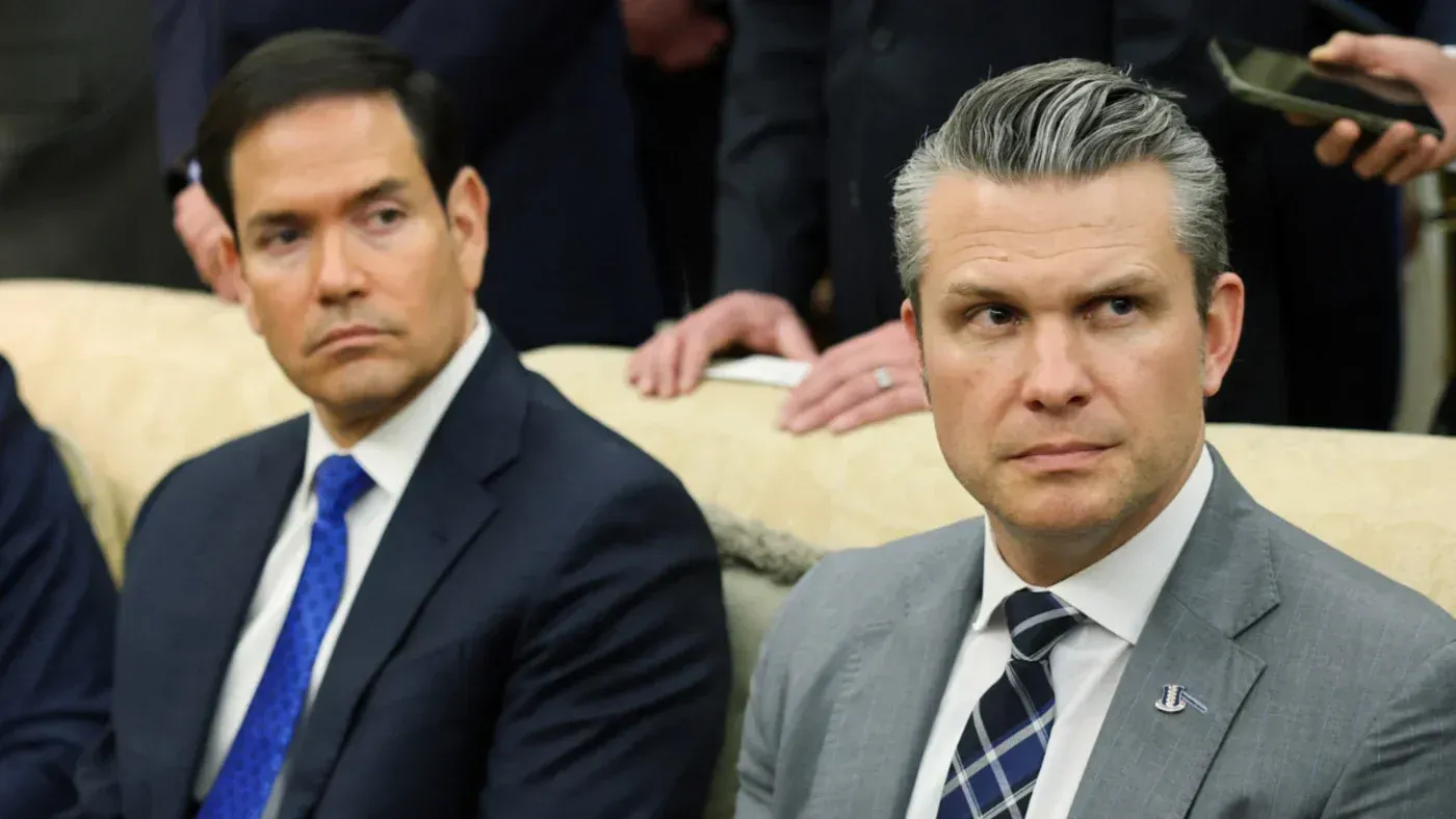 وزير الحرب الأمريكي بيتر هيغسيث ووزير الخارجية ماركو روبيو يجلسان معًا، مع تعبيرات وجه تعكس التوتر حول استراتيجية الولايات المتحدة تجاه إيران.