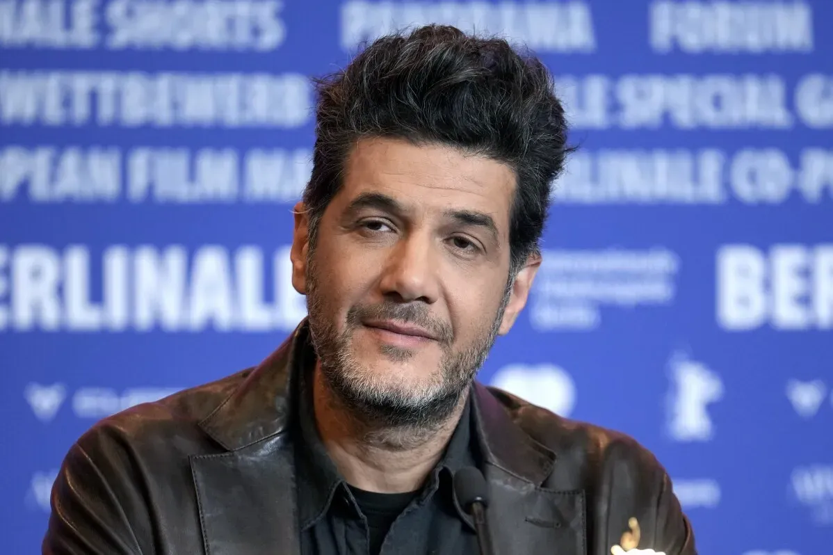 صورة لمخرج السينما نبيل عيوش خلال مؤتمر صحفي لمهرجان برلين السينمائي الدولي، مع خلفية تحمل شعار المهرجان.