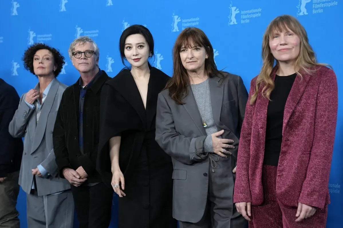 نجوم السينما يقفون معًا على السجادة الحمراء لمهرجان برلين السينمائي الدولي، مع خلفية زرقاء تحمل شعار المهرجان.