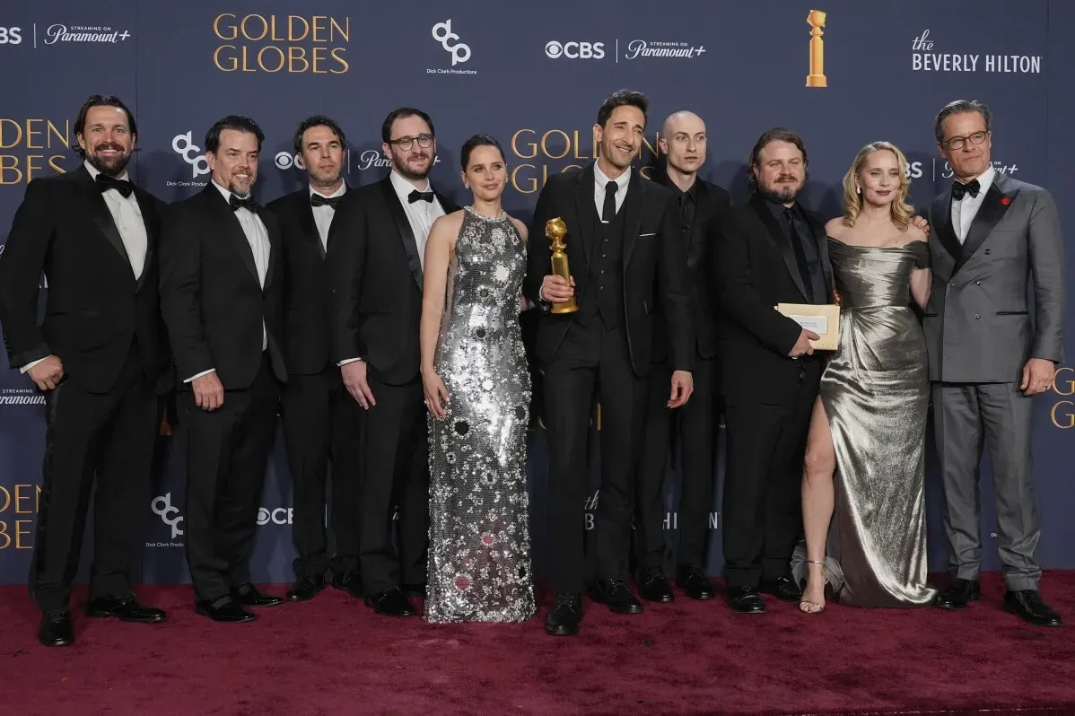 مجموعة من الممثلين وصناع الفيلم في حفل توزيع جوائز غولدن غلوب، مع وجود جاي بيرس حاملًا جائزة في المنتصف.