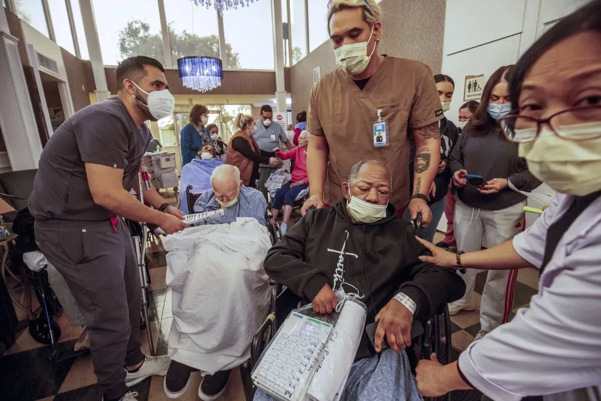 موظفون طبيون يساعدون مرضى مسنين في مركز رعاية، حيث يظهرون اهتمامًا ورعاية خلال فترة صعبة بعد حرائق الغابات في كاليفورنيا.