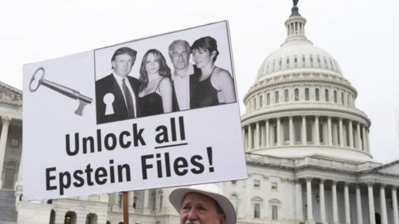 لافتة تطالب بفتح جميع ملفات إبشتاين، تظهر فيها صور لأشخاص معًا، أمام مبنى حكومي. تعكس المطالبات للكشف عن الوثائق المتعلقة بالفضائح.