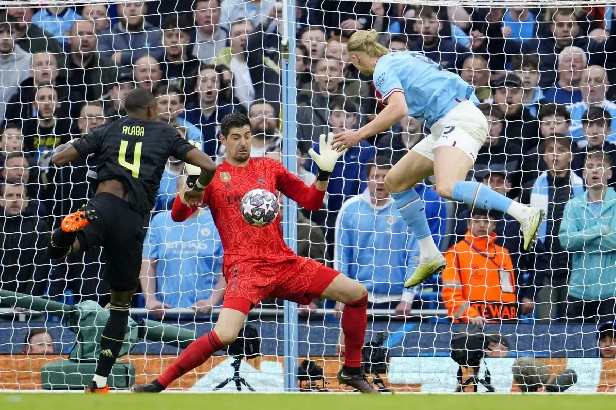 تداخل حاسم في مباراة دوري أبطال أوروبا بين ريال مدريد ومانشستر سيتي، يظهر فيها الحارس البلجيكي كورتوا يحاول التصدي للكرة.