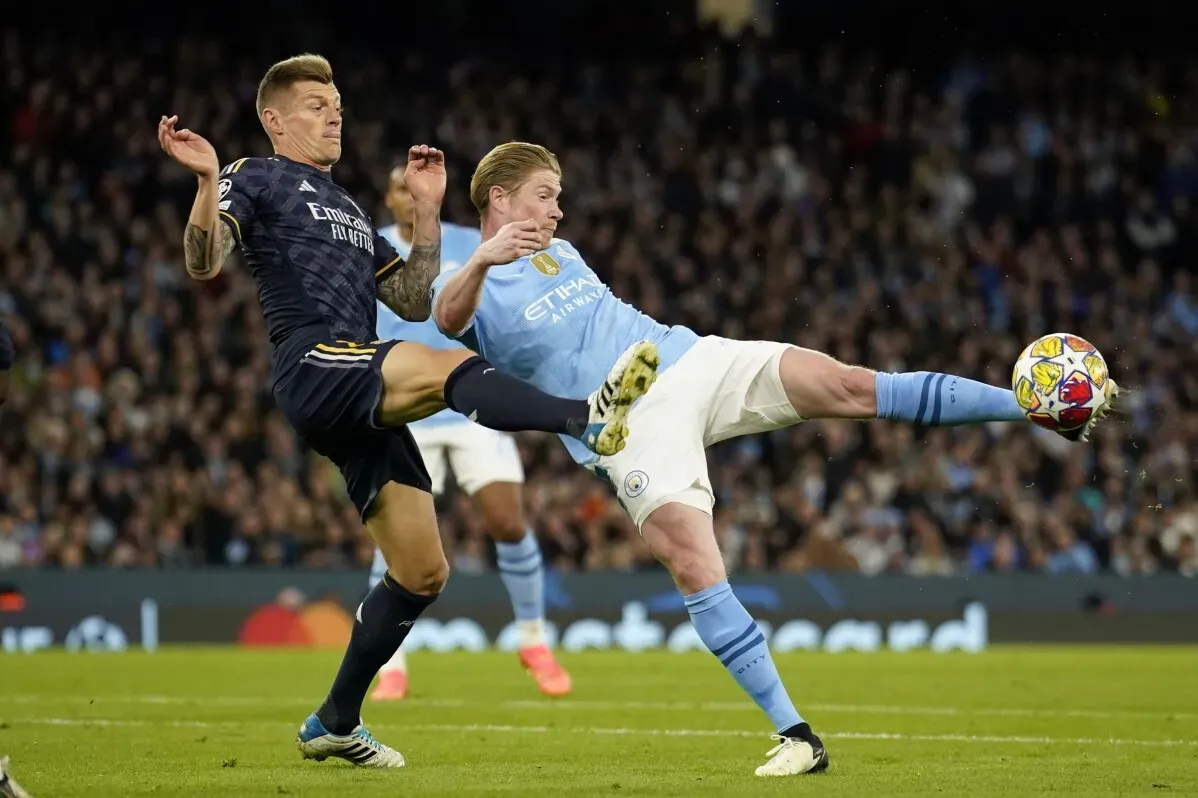 تصادم مثير بين لاعبي ريال مدريد ومانشستر سيتي في مباراة دوري أبطال أوروبا، يعكس التنافس الكبير بين الفريقين.