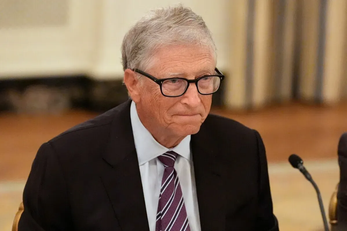 بيل غيتس يجلس في اجتماع رسمي، مع تعبير وجه يعكس الجدية، في سياق مراجعة العلاقة مع جيفري إبستين وسط تدقيق عام.