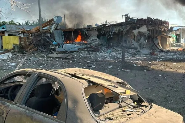 حطام سيارة ومباني محترقة في قرية أوكرانية بعد قصف صاروخي روسي أسفر عن مقتل وإصابة مدنيين وتدمير منازل.