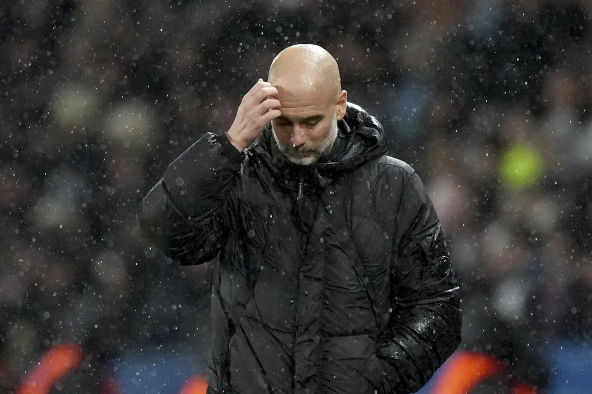 بيب جوارديولا، مدرب مانشستر سيتي، يبدو متفكراً تحت الأمطار بعد مباراة، مع توتر في عواطفه بسبب موقف فريقه في دوري أبطال أوروبا.