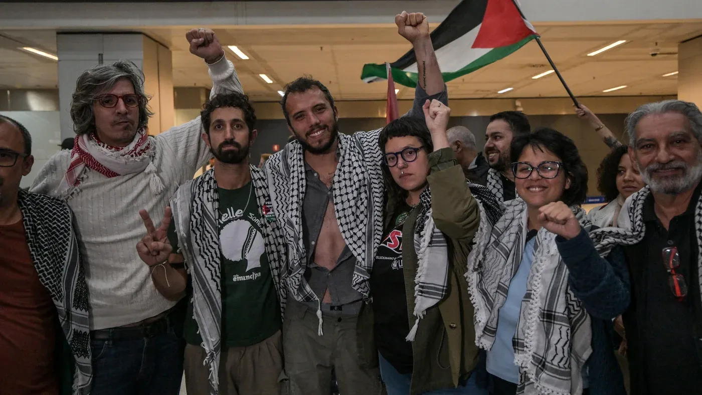 مجموعة من النشطاء الفلسطينيين يحتفلون بعد الإفراج عنهم، يرتدون الكوفية الفلسطينية ويرفعون الأعلام، معبرين عن التضامن والمقاومة.