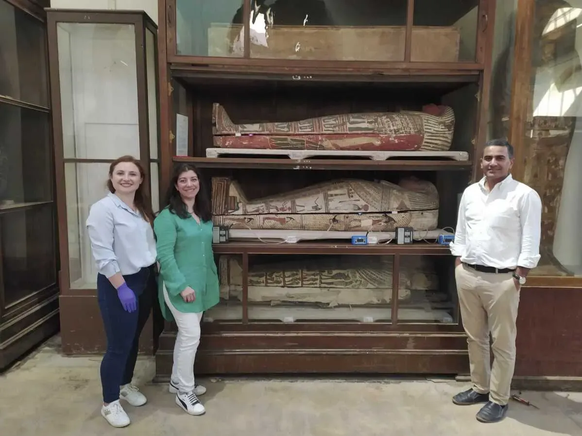 باحثون يقفون أمام مومياوات مصرية محفوظة في المتحف المصري، حيث يدرسون الروائح المرتبطة بعملية التحنيط.