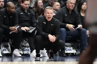 مدرب كرة السلة غرانت ماكسلاند يتفاعل بحماس على هامش المباراة، محاطًا بفريقه، في مواجهة بين تكساس تك وماونتنرز.