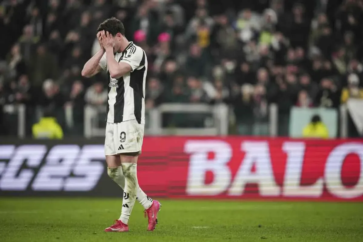 لاعب يوفنتوس يظهر علامات الإحباط بعد الخروج من كأس إيطاليا، مع خلفية جماهيرية تعبر عن خيبة الأمل.