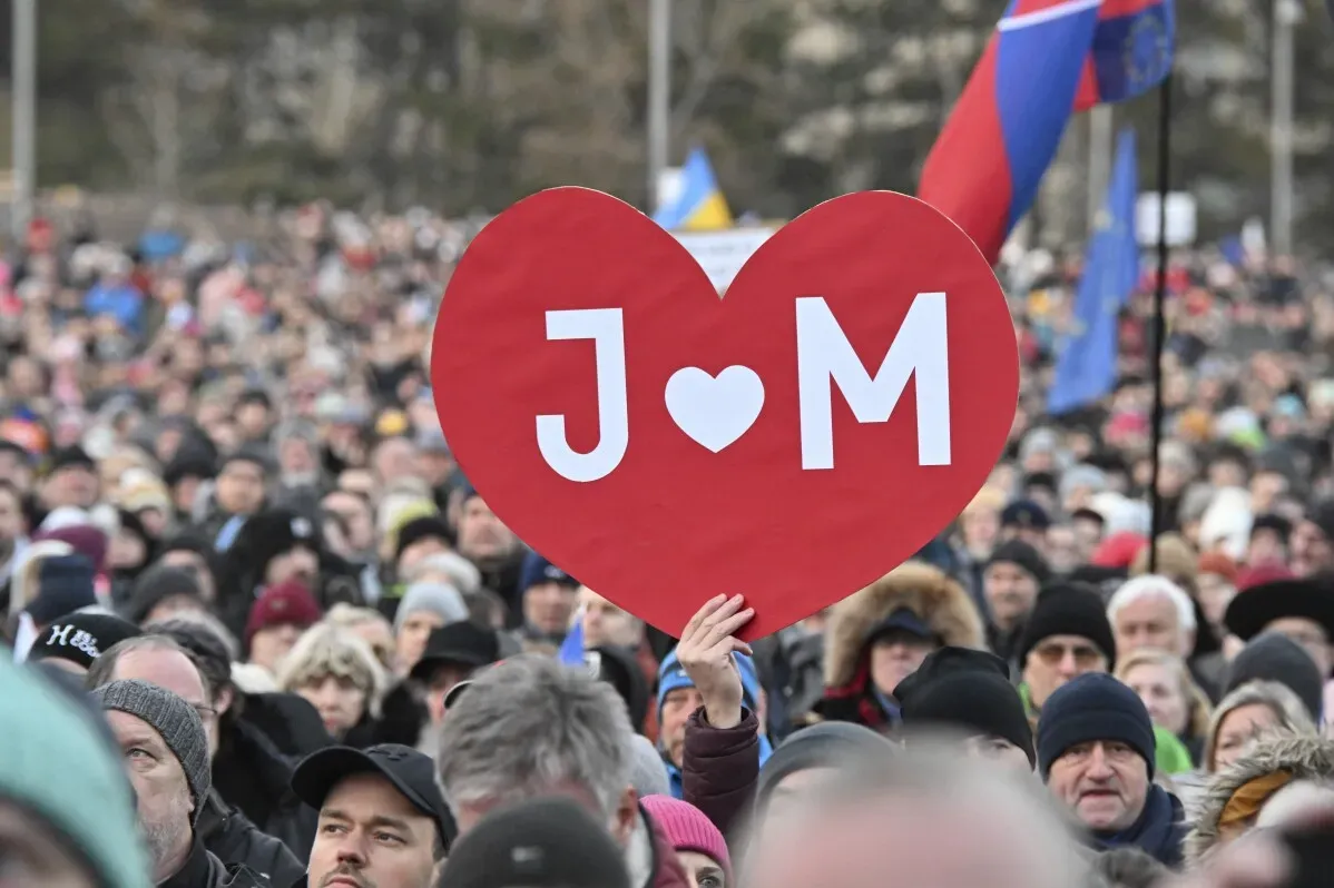حشود كبيرة في براتيسلافا تحمل لافتة على شكل قلب مكتوب عليها "J ♥ M" خلال احتجاجات لإحياء ذكرى مقتل الصحفي يان كوتشياك وخطيبته.