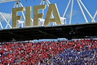 مؤسسة FIFA تظهر في الملعب مع جماهير متحمسة ترتدي ألوانًا حمراء وزرقاء، في فعالية لمكافحة خطاب الكراهية خلال كأس العالم.