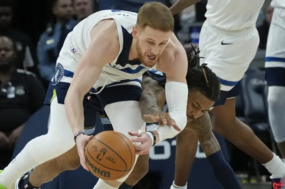 دونتي ديفينزينزو، لاعب مينيسوتا تمبروولفز، يتنافس على الكرة مع لاعب آخر خلال مباراة. يعاني ديفينزينزو من إصابة في إصبع القدم.