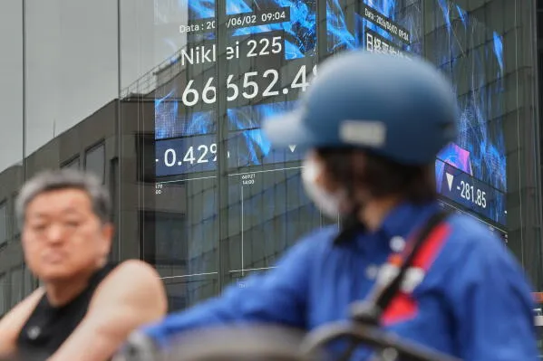 مؤشر Nikkei 225 يظهر في شاشة عرض في طوكيو، مع شخصين في المقدمة، حيث سجل ارتفاعًا تاريخيًا يتجاوز 68,000 نقطة.