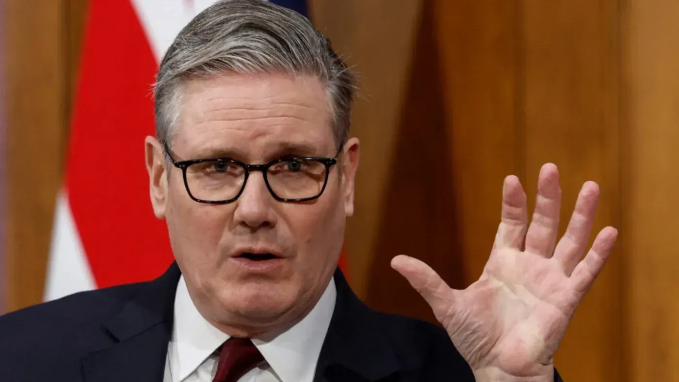 كير ستارمر، زعيم حزب العمال البريطاني، يتحدث بجدية خلال مؤتمر صحفي، مع العلم البريطاني خلفه، معبراً عن موقفه من الحرب في إيران.