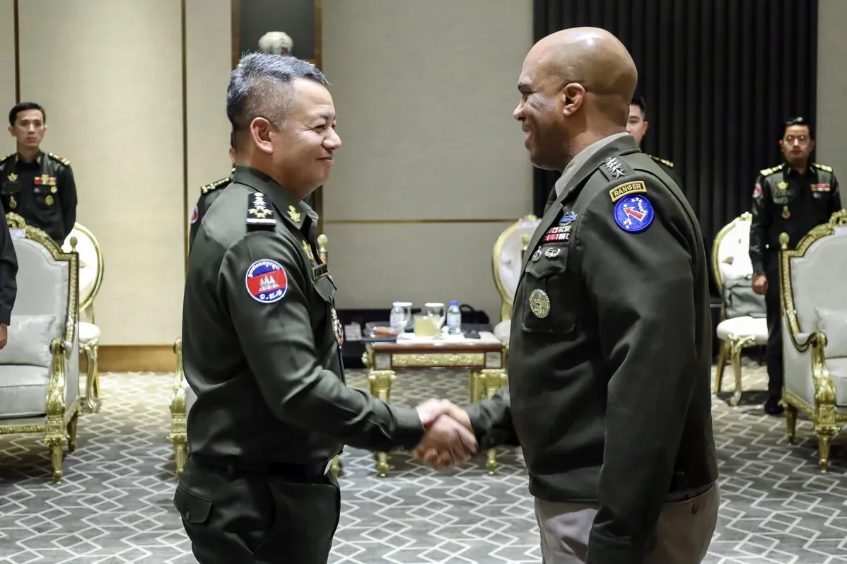 handshake between the Cambodian Army Chief General Mao Sophan and U.S. Army General Ronald B. Clark, highlighting military cooperation discussions in Phnom Penh.