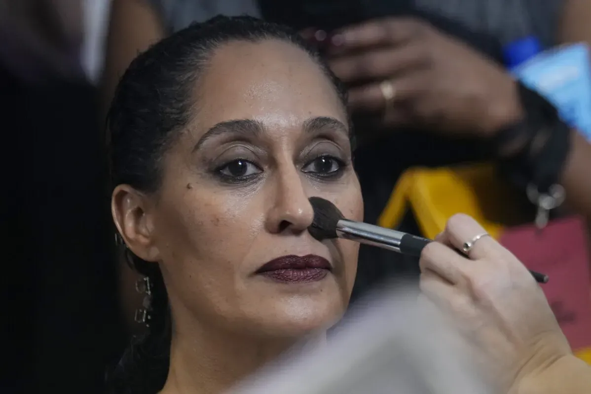 تظهر امرأة تتلقى مكياجاً قبل عرض أزياء مارني في ميلانو، مع التركيز على تفاصيل وجهها وتعبيراتها.