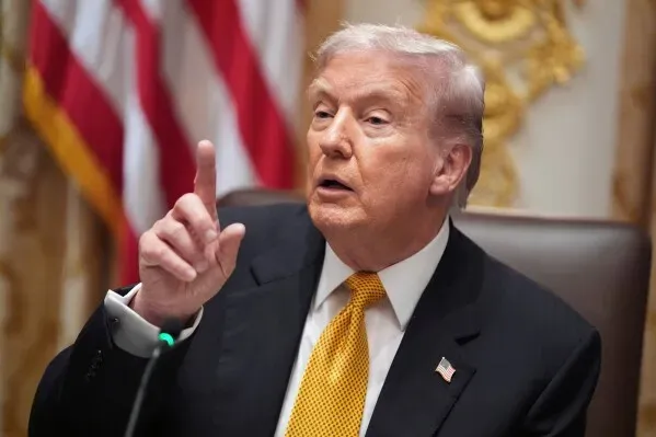 ترامب يتحدث خلال اجتماع، مشيرًا بإصبعه، مع العلم الأمريكي خلفه، حول ارتفاع أسعار لحوم البقر والتحقيقات في شركات التعبئة.