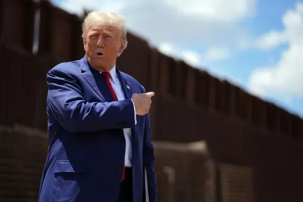 الرئيس دونالد ترامب يتحدث بجانب جدار الحدود، مع التركيز على قضايا الهجرة والترحيل، وسط توترات قانونية مع القضاء.