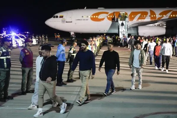 مهاجرون فنزويليون يغادرون طائرة في مطار، وسط إجراءات أمنية مشددة، في سياق عمليات ترحيل مثيرة للجدل إلى السلفادور.