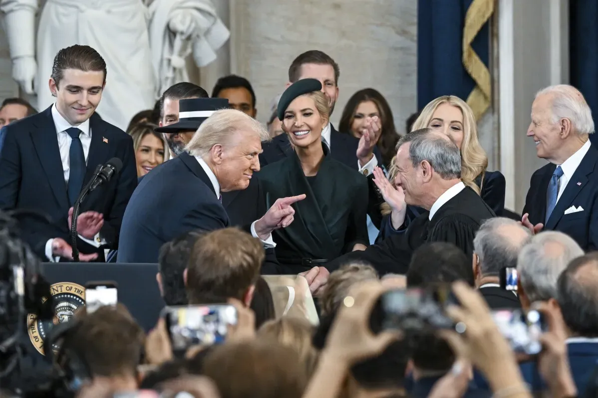 تظهر الصورة دونالد ترامب يتفاعل مع القاضي أثناء مراسم انتقال السلطة، محاطًا بكبار الشخصيات، بما في ذلك بايدن وإيفانكا ترامب.
