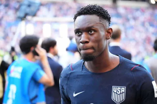 لاعب كرة القدم Folarin Balogun يرتدي زي منتخب الولايات المتحدة، في لحظة تأمل بعد مباراة كأس العالم المثيرة للجدل بسبب تدخل سياسي في إيقافه.