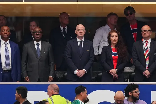 رئيس FIFA جياني إنفانتينو وسط مسؤولين خلال مباراة كأس العالم، في سياق جدل التدخل السياسي وتأجيل عقوبة اللاعب Balogun.