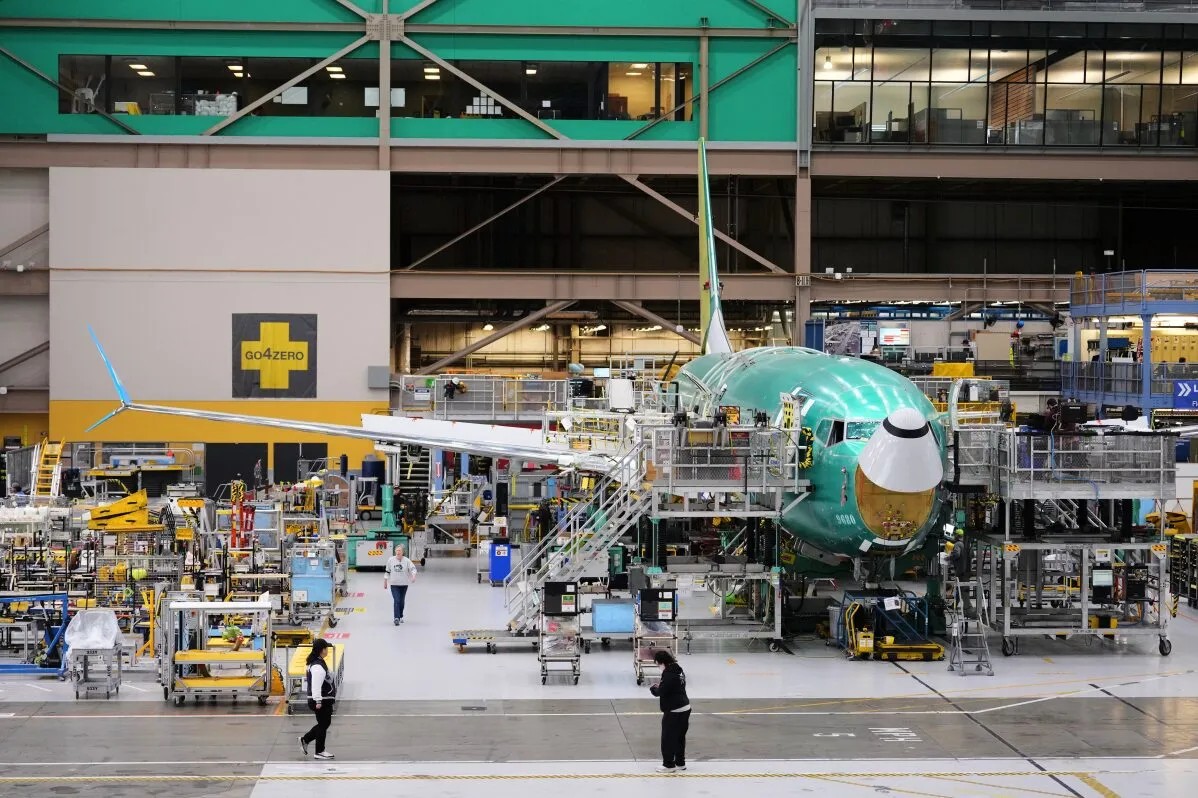 طائرة Boeing 737 Max في مصنعها، محاطة بعمال ومعدات، تمثل الصفقة المرتقبة مع الصين لشراء 200 طائرة.