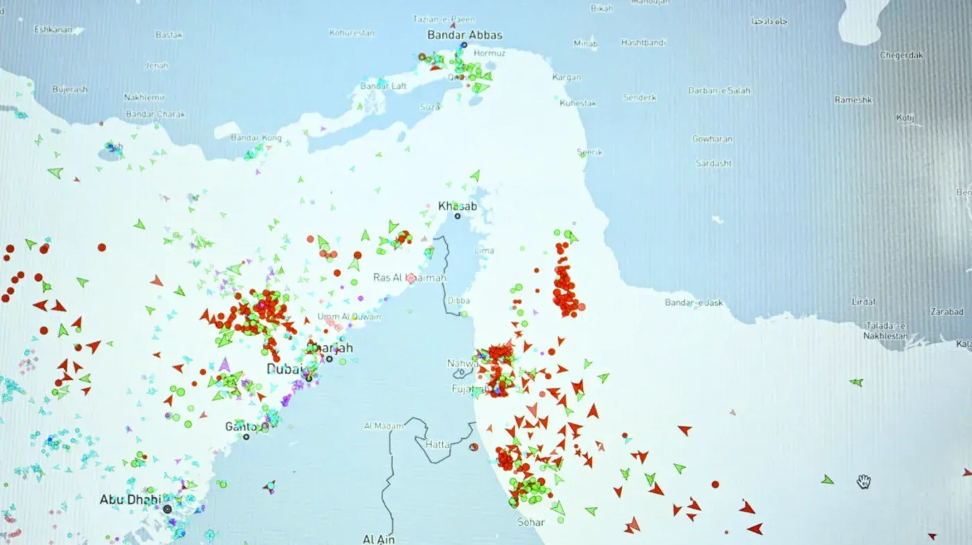خريطة توضح حركة السفن في مضيق هرمز، مع تمييز السفن المختلفة بألوان وأشكال متعددة، تعكس الوضع البحري والتوترات الإقليمية.